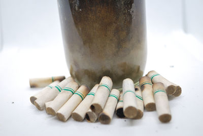 Close-up of cigarette on table against white background