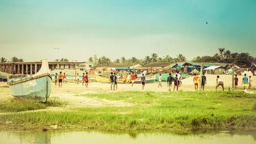 People on beach against clear sky