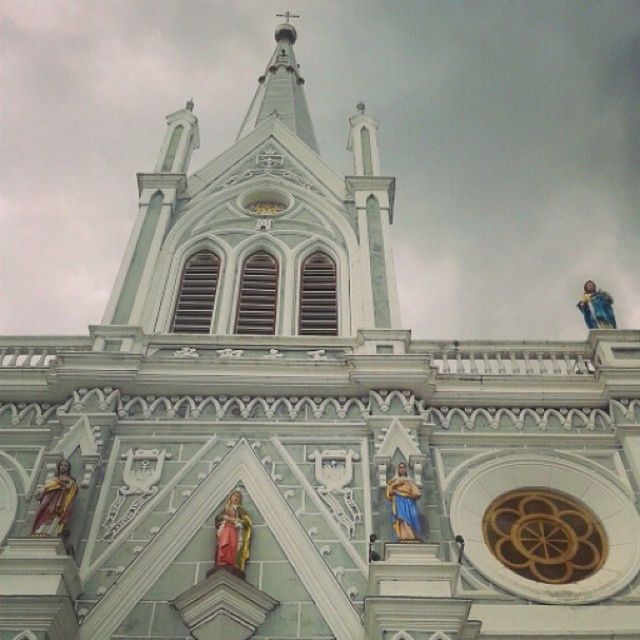 place of worship, religion, spirituality, church, architecture, low angle view, built structure, building exterior, sky, cathedral, cross, cloud - sky, human representation, famous place, travel destinations, statue, facade, sculpture