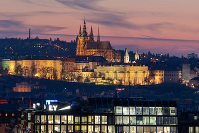 Illuminated buildings in city at dusk
