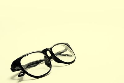 Close-up of eyeglasses on table against white background