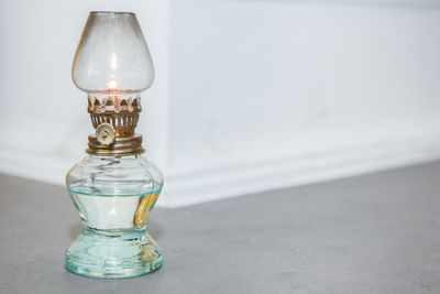 Close-up of light bulb on table against wall