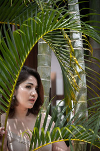 Portrait of young woman against plants