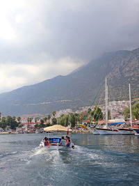 Sailboat sailing on sea against mountains