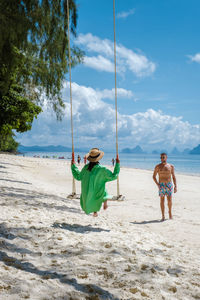 Children playing at beach against sky