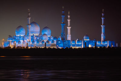 Illuminated buildings against sky at night