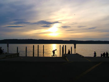 People at riverbank during sunset