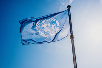 Low angle view of flag against blue sky