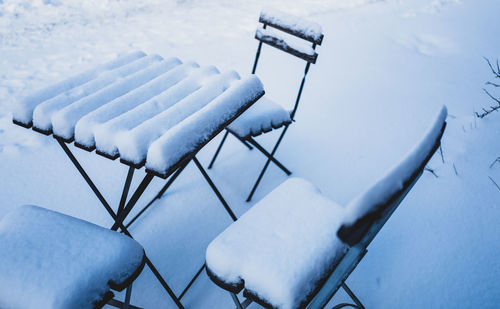 High angle view of empty chairs under snow