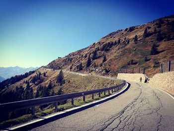 Road by mountain against clear blue sky