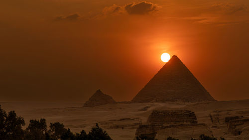 The sun on the top of the micerinos pyramid in giza. the sunset in the grand pyramid area.