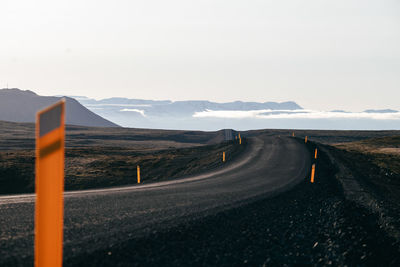 Empty road by mountain against sky