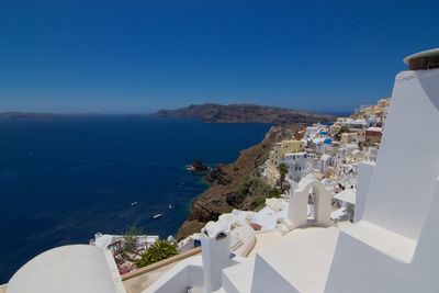 High angle view of town by sea against clear sky