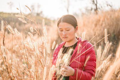 Portrait of young woman standing on field