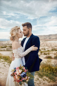 Young couple standing against stone wall