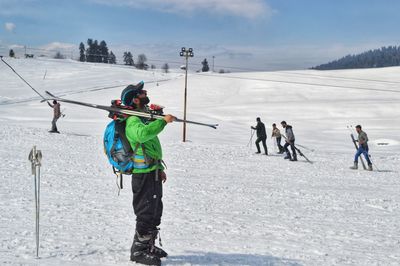 Man standing on snow covered land against sky