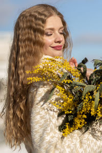 A woman with a bouquet of acacia flowers. the concept of the spring - march 8, easter, women's day.