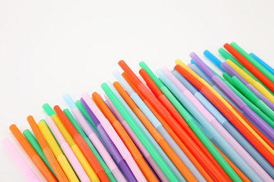 Close-up of colorful drinking straws against white background