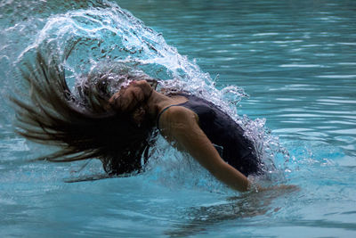 Girl tossing hair in swimming pool