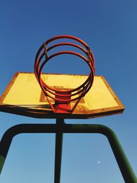 Low angle view of basketball hoop against clear blue sky