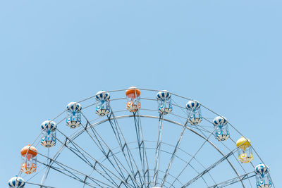 Low angle view of ferris wheel against clear blue sky