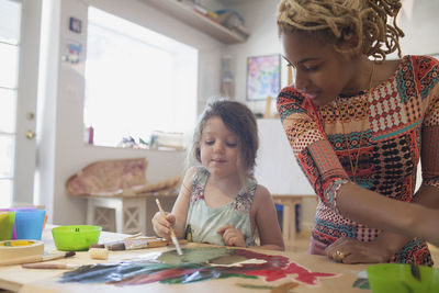 A young woman and girl painting