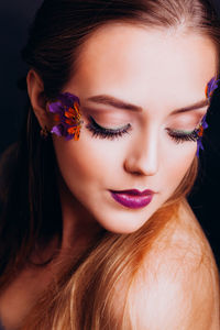 Close-up of beautiful woman against black background