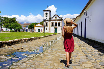 Back view of beautiful girl with walking towards the church of saint rita of cassia in paraty,brazil