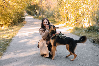 Woman with dog on field during autumn