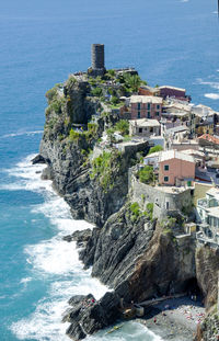 Sea by buildings in city against sky