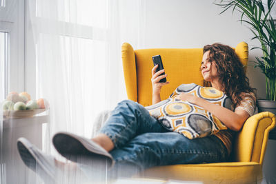 Portrait of woman sitting on bed at home