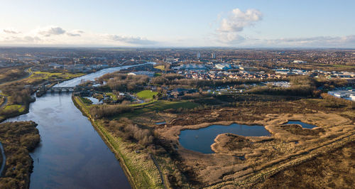 High angle view of river amidst cityscape against sky