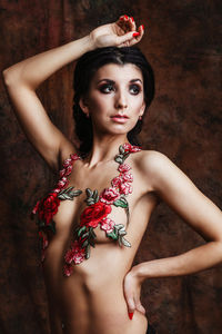 Portrait of young woman against red background