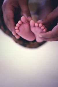Cropped image of parent holding baby feet