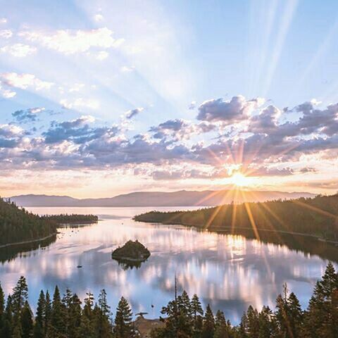 reflection, water, lake, tranquil scene, sun, scenics, tranquility, beauty in nature, sky, sunbeam, sunlight, nature, idyllic, sunset, tree, cloud - sky, mountain, cloud, standing water, lens flare, non-urban scene, calm, outdoors, no people, majestic, blue, travel destinations, lakeshore, tourism, non urban scene, remote, sunny, landscape, bright