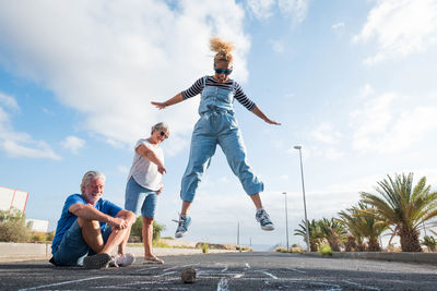 Low angle view of people on skateboard against sky