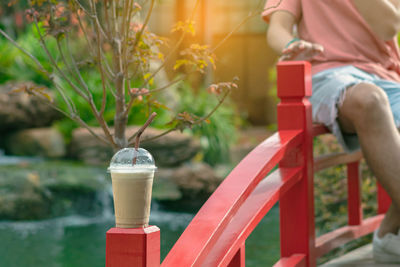 Midsection of woman sitting on railing