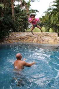 Full length of shirtless man swimming in pool