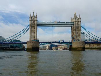 Golden gate bridge over river against cloudy sky