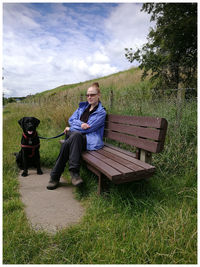 Full length of woman sitting on grass against sky