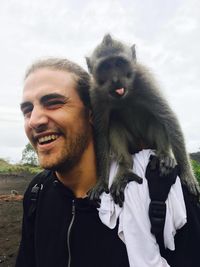 Close-up of cheerful man with monkey on shoulder