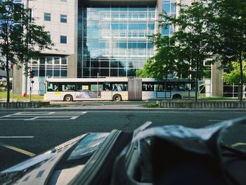 Cars on road by buildings in city