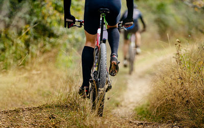 Rear wheel mountain bike riding on trail with dry grass