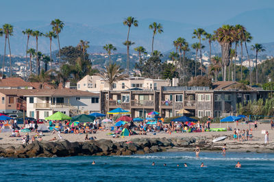 People swimming in pool by sea against sky