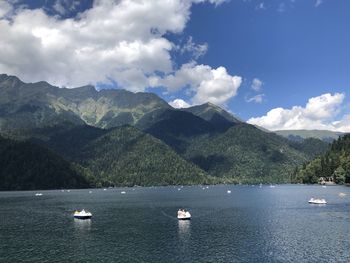 Scenic view of sea by mountains against sky