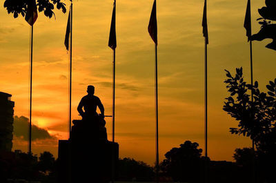 Silhouette man standing against orange sky