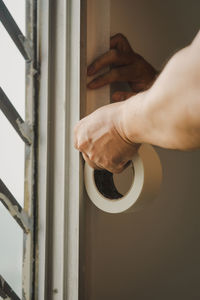 Cropped image of man holding masking tape