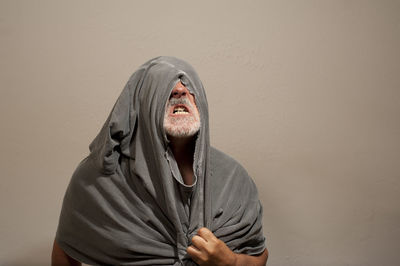 Portrait of man wearing hat against wall