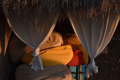 Front view of straw beach tent with accessories at sunset