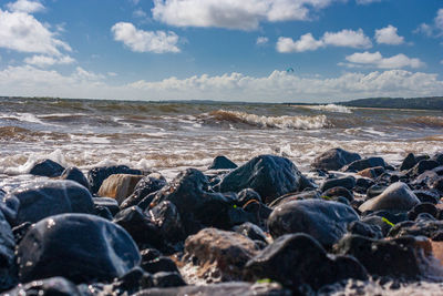 Rocks on beach against sky